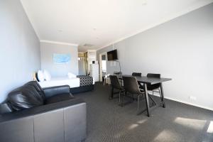 a room with a bed and a table and a couch at Old Maitland Inn - Rutherford in Maitland +32 photos