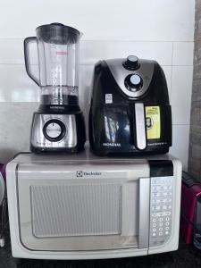 a blender sitting on top of a microwave at TROPICAL LAZER E EVENTOS - Casa em Lucas do Rio Verde in Lucas do Rio Verde