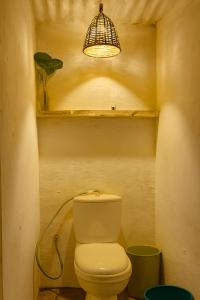 a bathroom with a toilet and a bird cage at Kapsula El Nido in El Nido