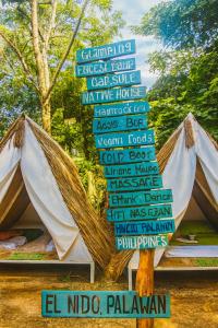a sign in front of a tent with a lot of signs at Kapsula El Nido in El Nido