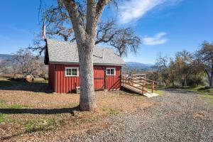a red cabin with a tree in front of it at Valley View Hideaway Cabin with Mountain Views in Miramonte