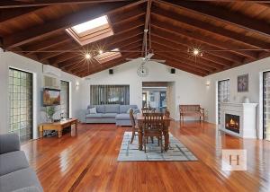 a living room with a table and a fireplace at Mannering Lake House in Mannering Park