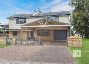 a house with a gate in front of it at Mannering Lake House in Mannering Park