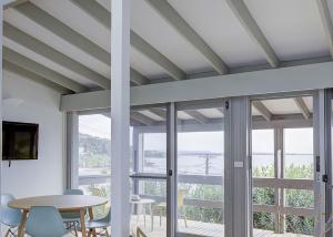 a dining room with windows and a table and chairs at Norah Beach Shack 1 in Norah +6 photos