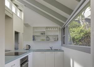 a kitchen with white cabinets and a large window at Norah Beach Shack 1 in Norah