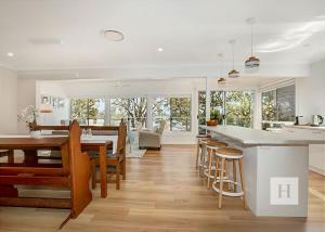 a kitchen and dining room with a table and chairs at Niaroo Lakeside in Summerland Point