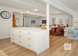 a white kitchen and living room with a clock at Niaroo Lakeside in Summerland Point