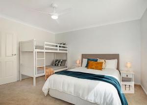 a bedroom with a bed and a bunk bed at Niaroo Lakeside in Summerland Point