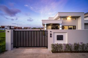 a white house with a gate in front of it at Solana Properties in Nadi