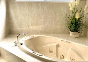 a white bath tub in a bathroom with flowers at Niaroo Lakeside in Summerland Point +28 photos