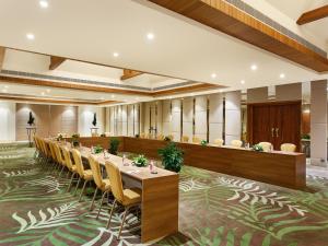 una grande stanza con un lungo tavolo e sedie di Taj Corbett Resort and Spa Uttarakhand a Ramnagar
