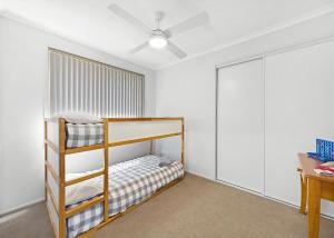 a bedroom with two bunk beds and a desk at The Sailor s Haven in Mannering Park