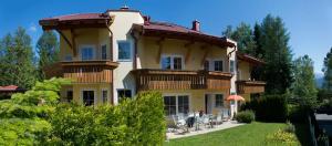 duży dom z ludźmi siedzącymi przed nim w obiekcie Haus Elisengrund am Geigenbuehel - chalet privé w mieście Seefeld in Tirol