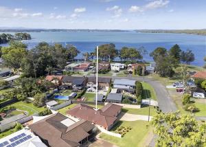 an aerial view of a town with houses and the water at The Sailor s Haven in Mannering Park