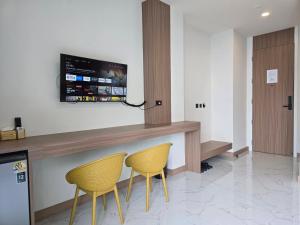a kitchen with two chairs and a counter with a tv at Northerly นอร์ทเทอร์ลี่ in Chiang Rai