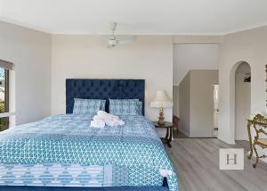a bedroom with a blue bed with two stuffed animals on it at Paradise Palms in Mannering Park