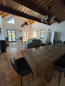 a living room with a large wooden table and chairs at Panoráma Villa Vágáshuta in Vágáshuta