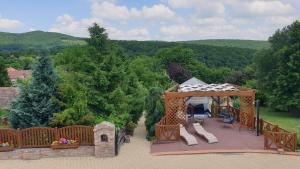 a deck with a gazebo and a playground at Panoráma Villa Vágáshuta in Vágáshuta