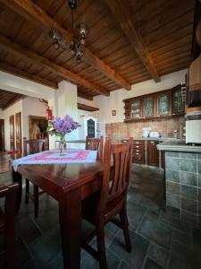 a kitchen and dining room with a wooden table and chairs at Panoráma Villa Vágáshuta in Vágáshuta +19 photos