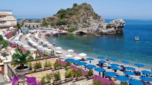 a beach with blue and white umbrellas and the ocean at Luxury Apartment Federica N 1 Centro Storico di Taormina in Taormina