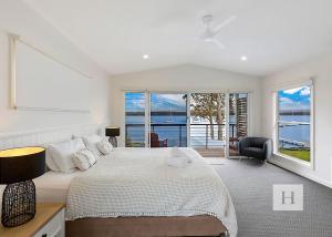 a bedroom with a bed and a view of the ocean at Sunset Central Coast in Mannering Park