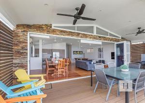 a dining room and living room with a table and chairs at Sunset Central Coast in Mannering Park