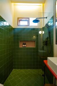 a green tiled bathroom with a shower and a sink at Songbird Boutique Inn in Canggu +129 photos