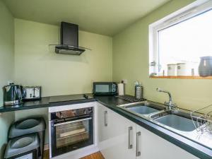 a kitchen with a sink and a microwave at Mars 4 - Uk50474 in Greenhaugh