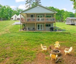 a house with a deck and chairs in the yard at Dockside Dreamz 2 with beach & dock in Clarksville