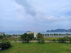 a view of a park with a building and the water at A59 Memory Hotel Tuan Chau in Ha Long