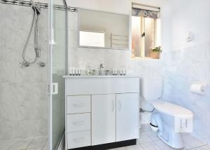 a white bathroom with a sink and a shower at Sparkling Waters in Rathmines +19 photos
