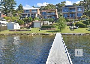 a dock in a body of water with houses at Sparkling Waters in Rathmines