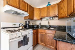 a kitchen with wooden cabinets and a white stove top oven at Old Town Cottonwood Cottage in Cottonwood