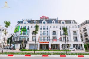 a white building with a sign on top of it at Khách sạn đẹp Hà Nội - Royal Louis Hotel in Dại Mõ