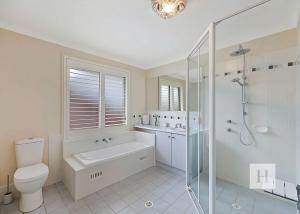 a bathroom with a toilet and a sink and a shower at Sunset Lakehouse in Toukley +8 photos