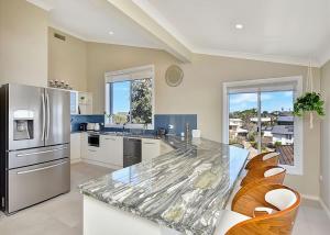 a kitchen with a counter top and a refrigerator at The Sea Serenade in Blacksmiths