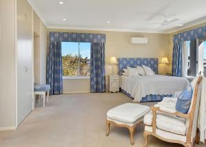 a bedroom with a large bed with blue curtains at The Sea Serenade in Blacksmiths