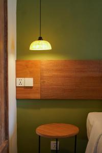 a room with a table and a light on a green wall at Songbird Boutique Inn in Canggu