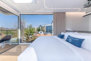 a bedroom with a white bed and a large window at Air Space Camp Khao Yai in Pak Chong