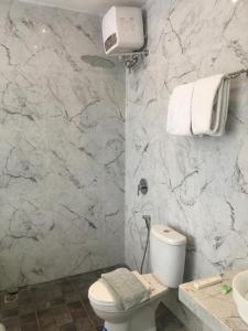 a bathroom with a white toilet and a sink at Edu HOTEL Y-SKANAM SYARIAH in Surabaya +13 photos
