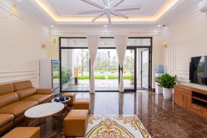 a living room with a couch and a tv at Khách sạn đẹp Hà Nội - Royal Louis Hotel in Dại Mõ