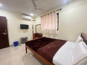 a bedroom with a large bed and a television at The cozy Inn in Calangute