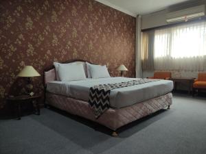 a bedroom with a large bed in a room at Edu HOTEL Y-SKANAM SYARIAH in Surabaya