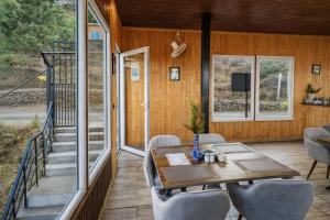 a screened in porch with a table and chairs at Pine Country Resort in Mukteshwar