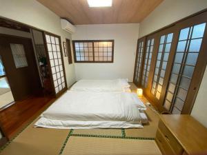 a bedroom with a large bed in a room with windows at お宿るり嘉鉄 in Setouchi