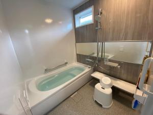 a bathroom with a bath tub and a toilet at お宿るり嘉鉄 in Setouchi +14 photos