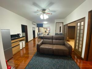 a living room with a couch and a ceiling fan at お宿るり嘉鉄 in Setouchi