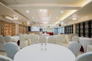 a banquet hall with white tables and chairs at Hotel Silver Inn Near Mumbai Airport in Mumbai