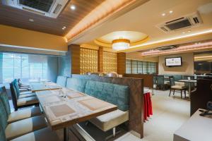 a restaurant with a long table and chairs at Hotel Silver Inn Near Mumbai Airport in Mumbai