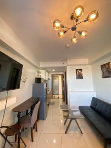 a living room with a dining room table and a chandelier at Carlota247 in Cebu City